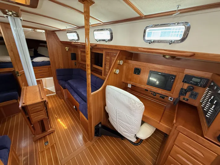 Chance Yacht Photos Pics Interior of a 1999 Tartan 4100 sailboat with wood paneling and blue seating.