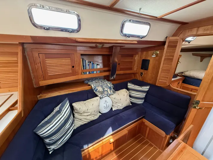 Chance Yacht Photos Pics Cozy interior of 1999 Tartan 4100 sailboat with navy cushions and wooden cabinetry.