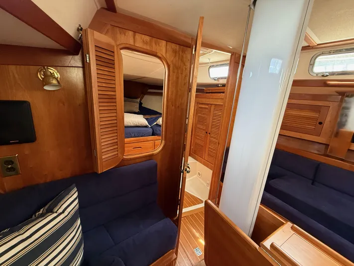 Chance Yacht Photos Pics Interior of a 1999 Tartan 4100 sailboat with wooden finishes and blue seating.