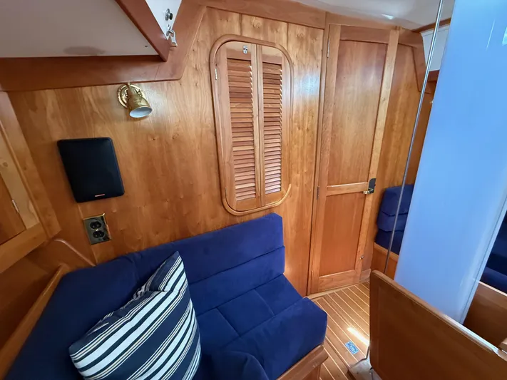 Chance Yacht Photos Pics Cozy interior of 1999 Tartan 4100 yacht with wooden paneling and blue seating.