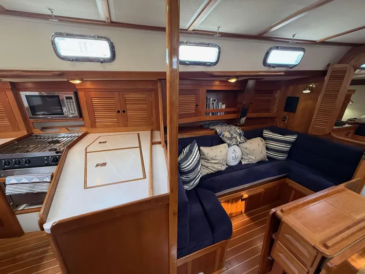 Chance Yacht Photos Pics Interior of 1999 Tartan 4100 sailboat with cozy seating and wooden cabinetry.