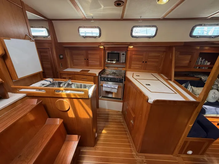Chance Yacht Photos Pics Interior of a 1999 Tartan 4100 sailboat, featuring a wooden kitchen and dining area.