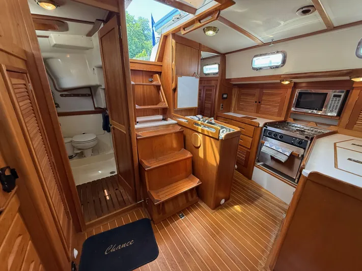 Chance Yacht Photos Pics Interior of 1999 Tartan 4100 sailboat with wooden cabinetry and compact kitchen.