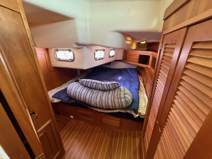 Chance Yacht Photos Pics Cozy cabin interior of 1999 Tartan 4100 sailboat with wooden finishes and porthole windows.