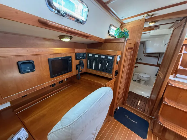 Chance Yacht Photos Pics Navigation station and cabin interior of 1999 Tartan 4100 sailboat, featuring wood finish and equipment.
