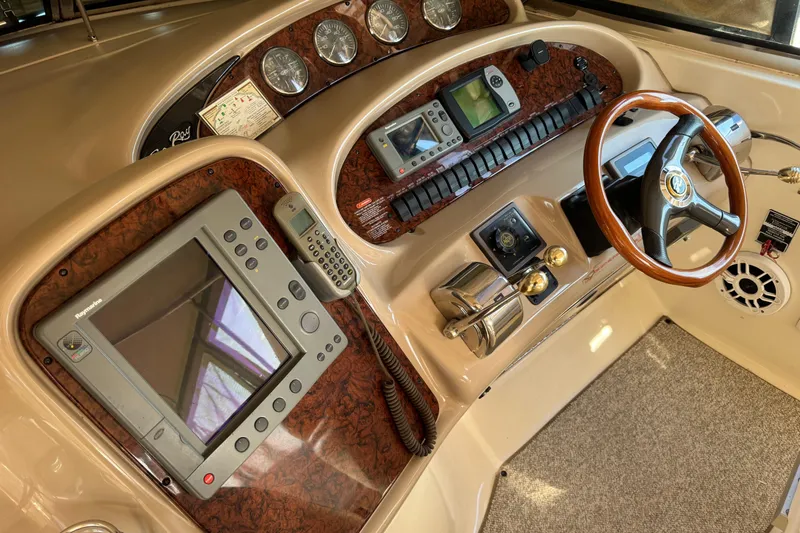 Solid Rock Yacht Photos Pics 2003 Sea Ray 380 Sundancer helm with navigation instruments and wood-accented steering wheel.