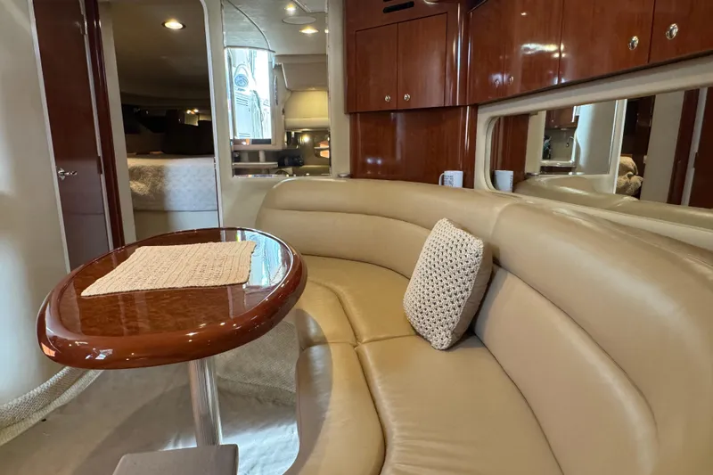 Solid Rock Yacht Photos Pics Luxurious interior of 2003 Sea Ray 380 Sundancer yacht with leather seating and wooden table.