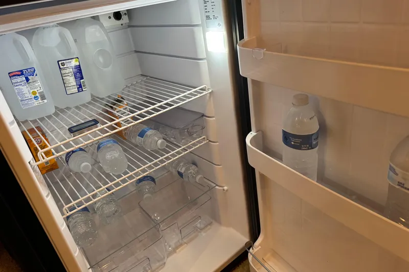 Solid Rock Yacht Photos Pics Refrigerator stocked with water bottles and jugs on a Sea Ray 380 Sundancer, 2003 model.