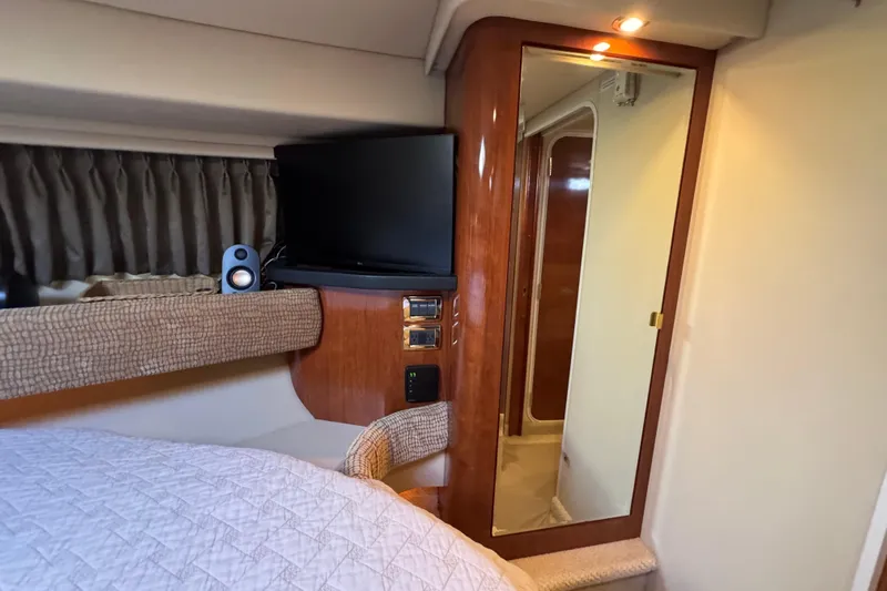 Solid Rock Yacht Photos Pics Interior of 2003 Sea Ray 380 Sundancer with TV, mirror, and cozy bedding.