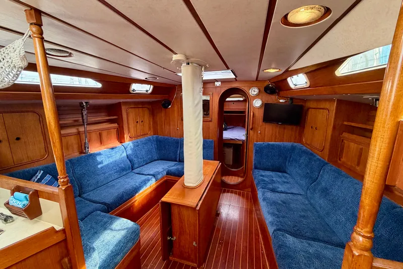 Pacific Pearl Yacht Photos Pics Interior of 1991 Oyster Lightwave 48 yacht with blue seating and wooden finishes.