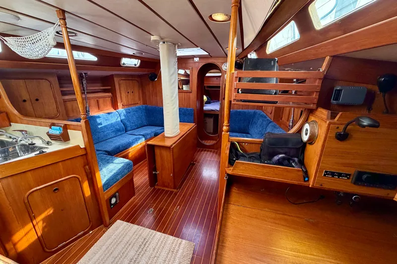 Pacific Pearl Yacht Photos Pics Interior of 1991 Oyster Lightwave 48 yacht with wooden finish and blue seating.