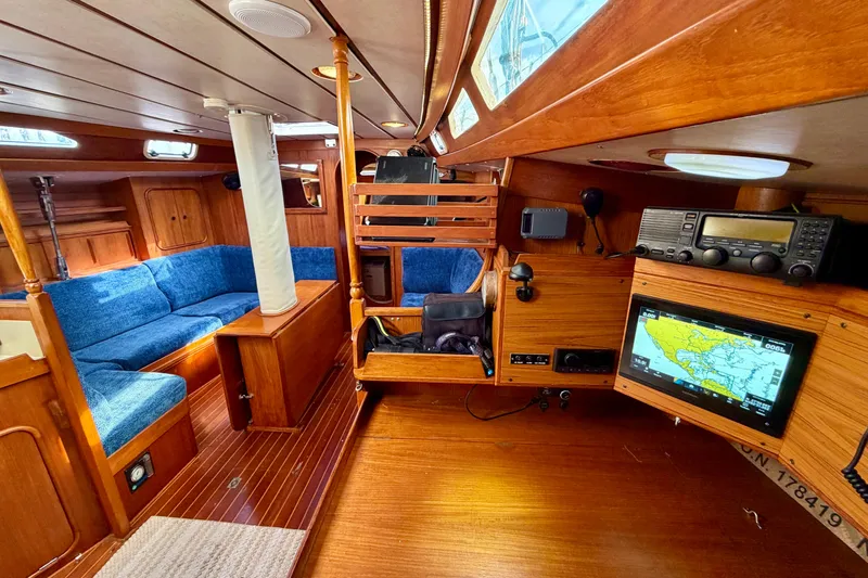 Pacific Pearl Yacht Photos Pics Interior of 1991 Oyster Lightwave 48 yacht with blue seating and navigation equipment.