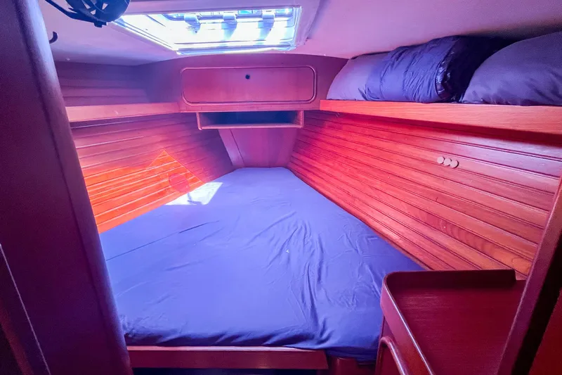 Pacific Pearl Yacht Photos Pics Cozy cabin interior of 1991 Oyster LW48 yacht with wooden paneling and skylight.