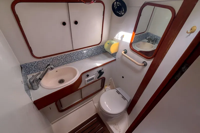 Pacific Pearl Yacht Photos Pics Bathroom interior of 1991 Oyster LW48 yacht with sink, toilet, and mirror.