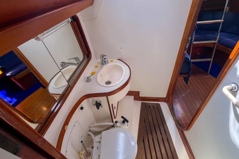 Pacific Pearl Yacht Photos Pics Bathroom interior of 1991 Oyster LW48 yacht with wooden accents and compact design.
