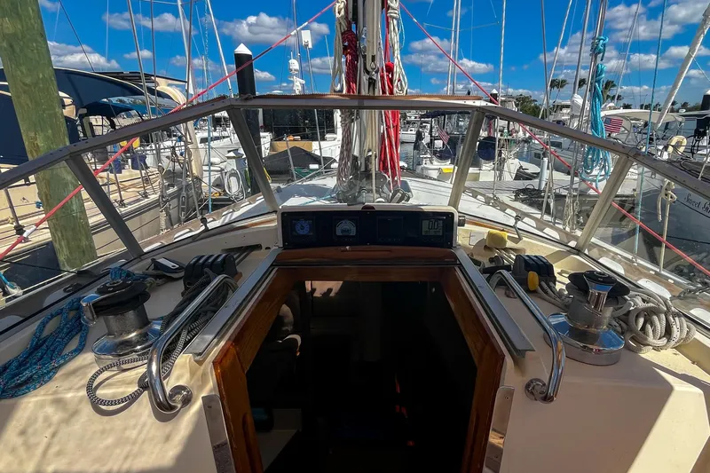 Pacific Pearl Yacht Photos Pics Cockpit view of 1991 Oyster LW48 sailboat docked at marina under blue sky.