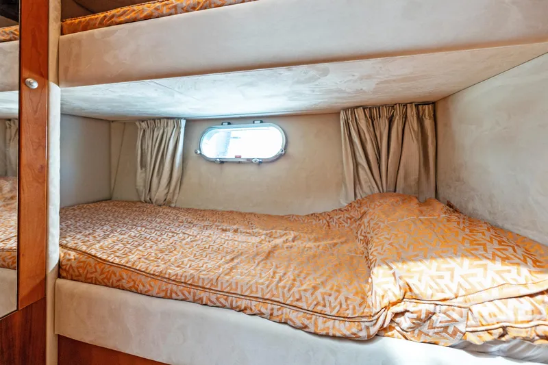  Yacht Photos Pics Bunk beds in 2008 Sunseeker Manhattan 70 yacht cabin with orange bedding and porthole window.