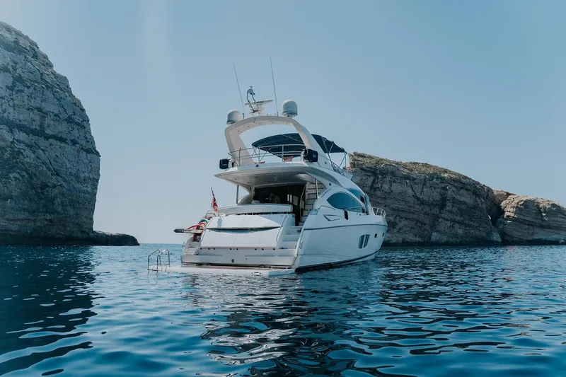  Yacht Photos Pics Luxury Sunseeker Manhattan 70 yacht, 2008 model, anchored near rocky cliffs.