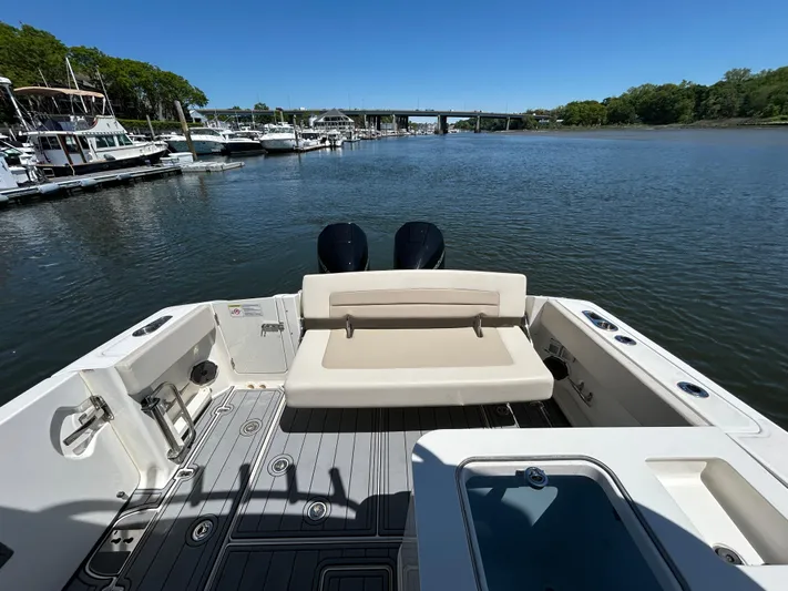  Yacht Photos Pics Boston Whaler 320 Vantage 2021 boat interior with seating, docked by a serene waterfront.