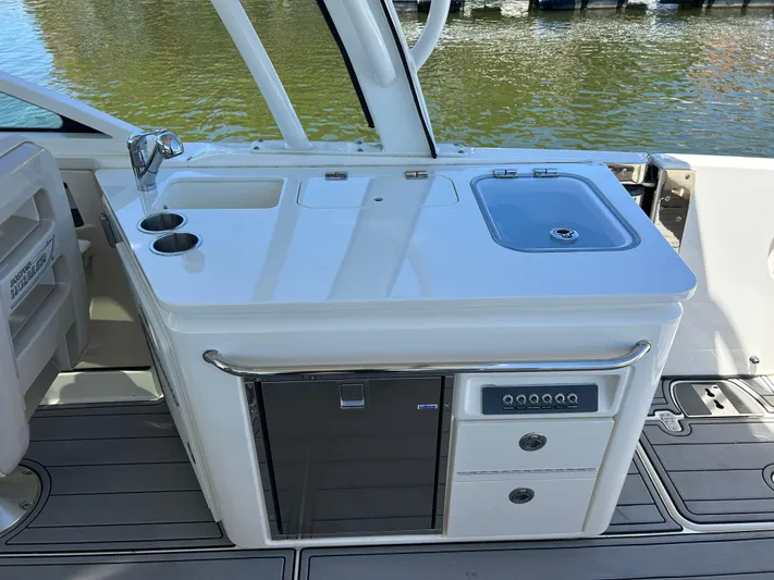  Yacht Photos Pics 2021 Boston Whaler 320 Vantage boat kitchenette with sink, storage, and sleek design.