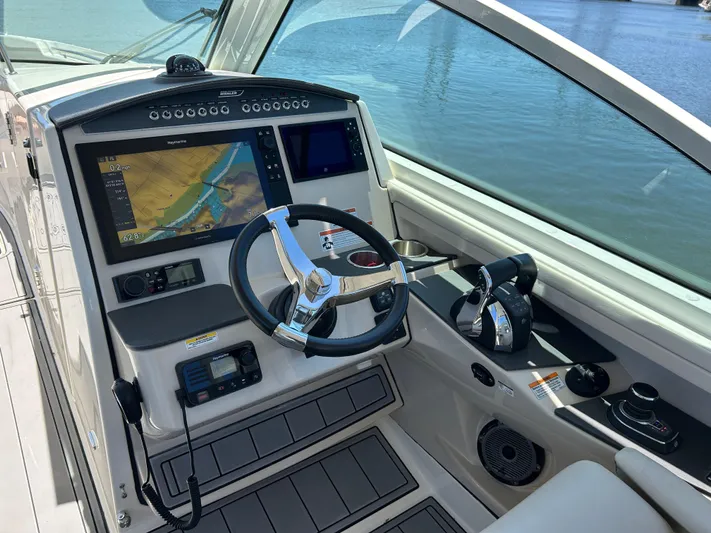  Yacht Photos Pics 2021 Boston Whaler 320 Vantage helm with navigation screens and steering wheel, overlooking water.