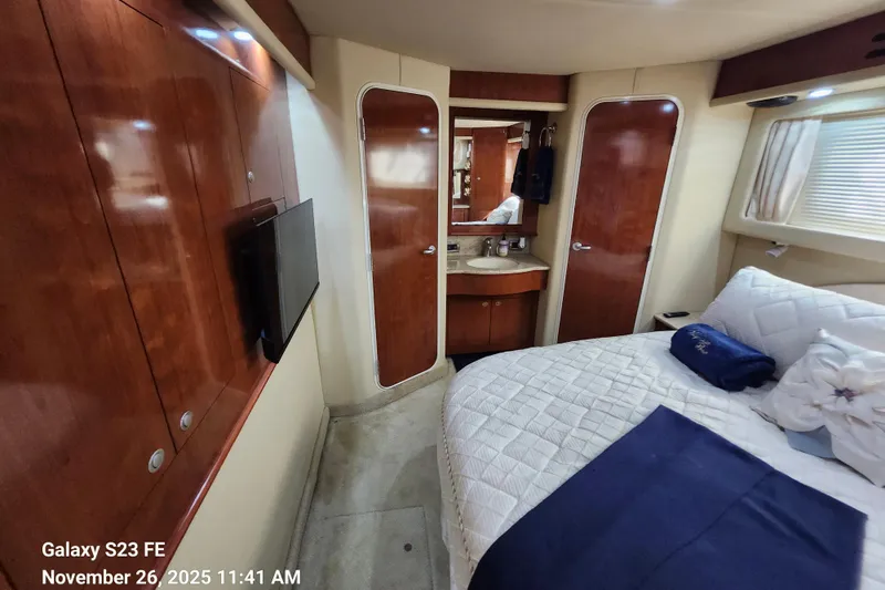 Magnolia Belle Yacht Photos Pics Interior of 2004 Sea Ray 390 Motor Yacht with bed, TV, and wooden cabinetry.