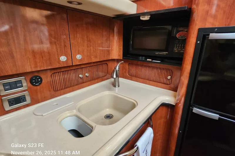 Magnolia Belle Yacht Photos Pics 2004 Sea Ray 390 Motor Yacht kitchen with sink, microwave, and wooden cabinetry.