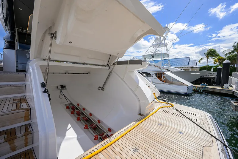  Yacht Photos Pics Open storage compartment on 2026 Princess S72 yacht, docked at marina under blue sky.