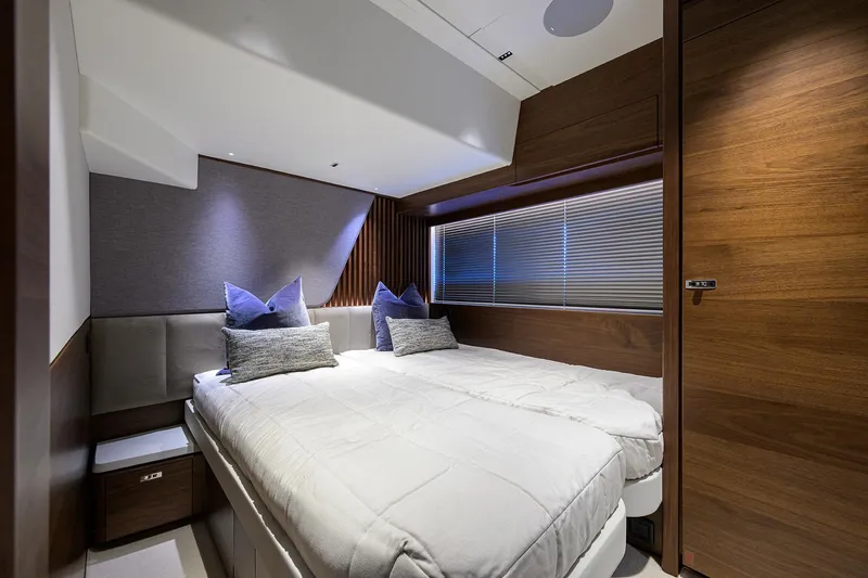  Yacht Photos Pics Luxurious cabin interior of 2026 Princess S72 yacht with modern bedding and wooden accents.