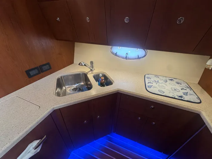  Yacht Photos Pics 2006 Tiara Yachts 4200 Open kitchen with sink, countertop, and nautical-themed mat.