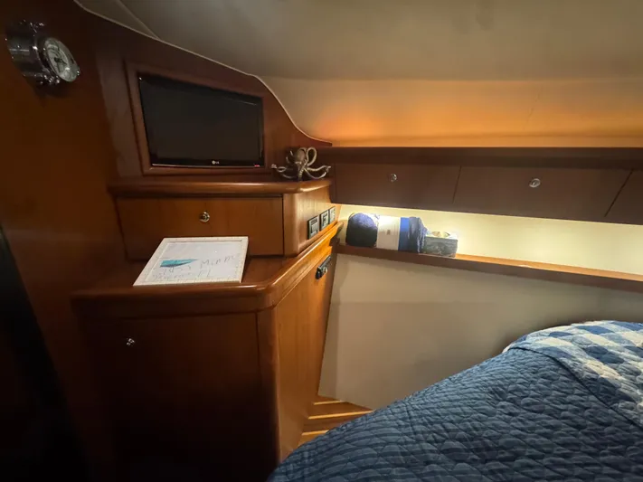  Yacht Photos Pics 2006 Tiara Yachts 4200 Open cabin interior with wood cabinetry and cozy bedding.