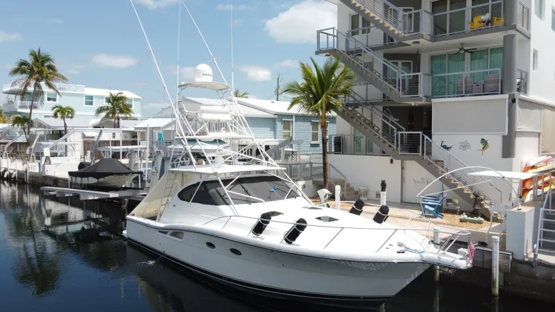  Yacht Photos Pics 2006 Tiara Yachts 4200 Open docked near modern waterfront homes, palm trees, and clear skies.