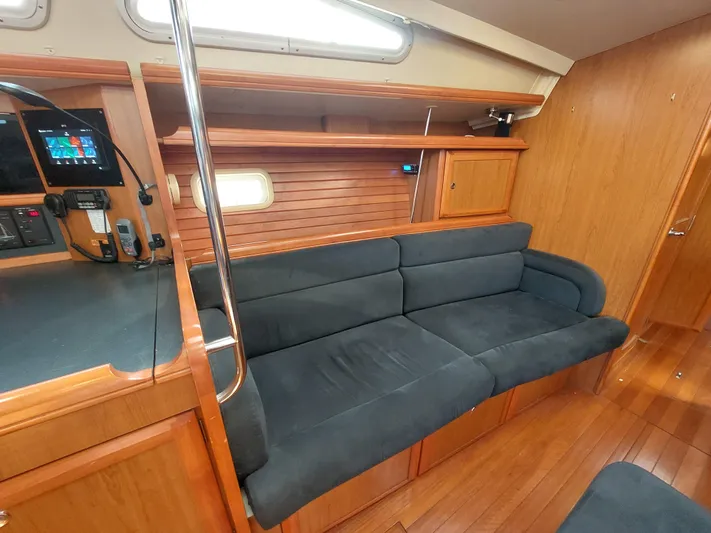 "heron" Yacht Photos Pics 2009 Hunter 49 yacht interior with wooden finish and black sofa.