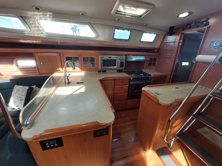 "heron" Yacht Photos Pics Interior of 2009 Hunter 49 yacht with modern kitchen and wooden cabinetry.