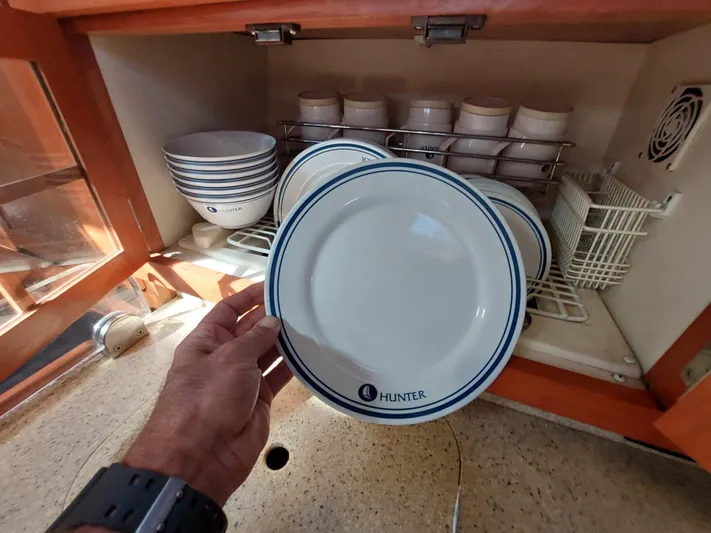 "heron" Yacht Photos Pics Hand holding Hunter plate in a kitchen cabinet, Hunter 49 model, 2009.