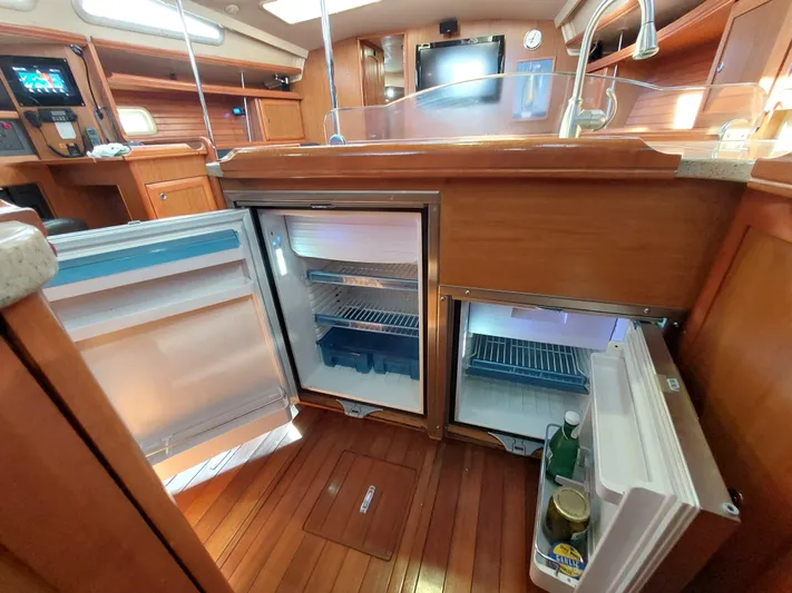"heron" Yacht Photos Pics 2009 Hunter 49 yacht interior with open fridge, wooden flooring, and modern kitchen amenities.