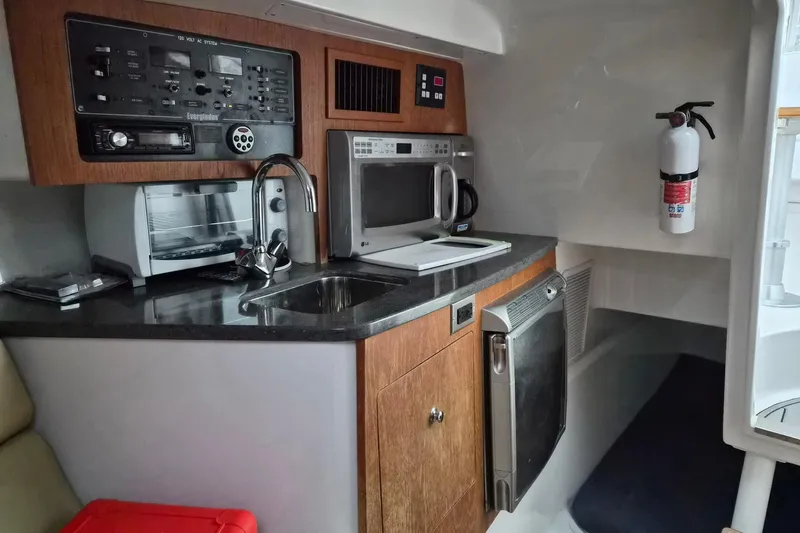 Paradise Bound Yacht Photos Pics Compact kitchen area in a 2008 Everglades 350LX boat with appliances and safety equipment.