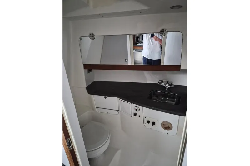 Paradise Bound Yacht Photos Pics 2008 Everglades 350LX boat bathroom interior with sink, mirror, and toilet.