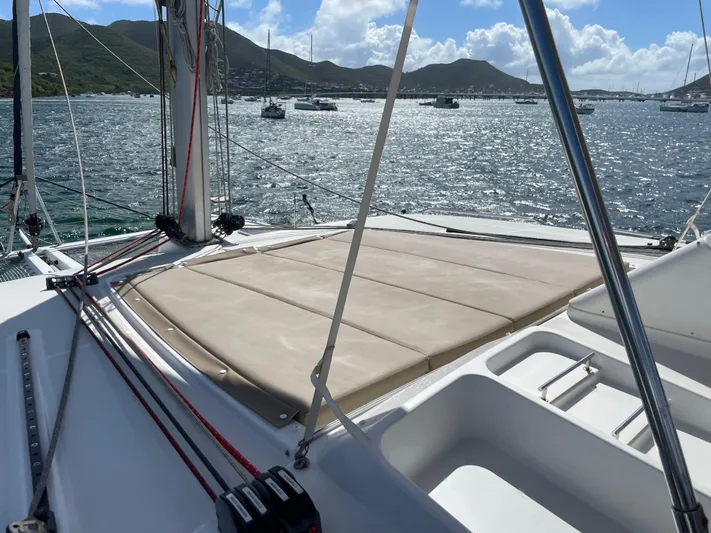 Pasha Yacht Photos Pics Lagoon 450F catamaran deck with sunbathing area, anchored in scenic bay, 2012 model.