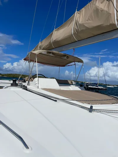 Pasha Yacht Photos Pics Sailing catamaran Lagoon 450F, 2012 model, with beige canopy, docked under blue sky.