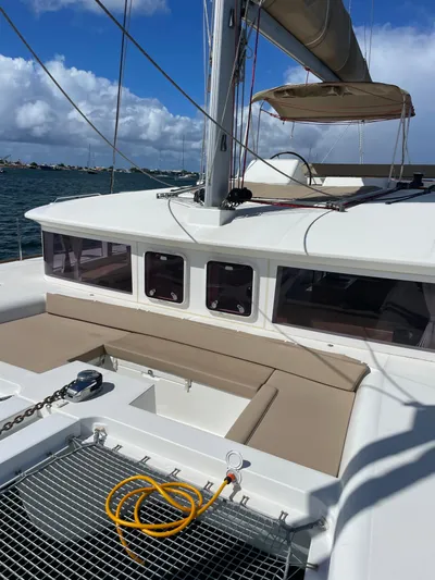 Pasha Yacht Photos Pics 2012 Lagoon 450F catamaran deck with netting and seating, under a clear blue sky.