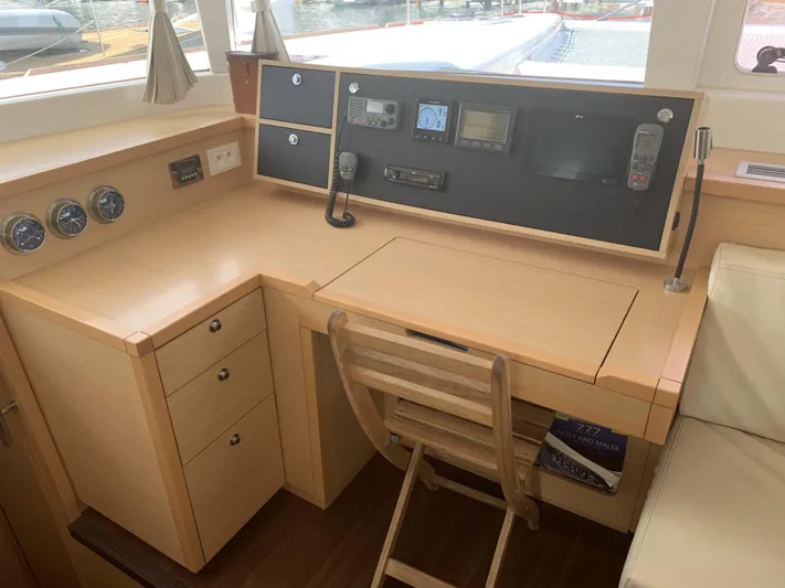Pasha Yacht Photos Pics Navigation station inside a 2012 Lagoon 450F catamaran with control panels and wooden desk.