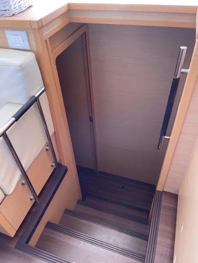 Pasha Yacht Photos Pics Staircase leading below deck on 2012 Lagoon 450F yacht, featuring wooden steps and handrail.