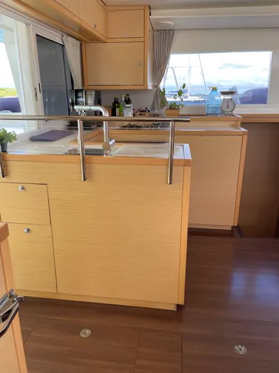 Pasha Yacht Photos Pics Interior of 2012 Lagoon 450F yacht kitchen with wooden cabinetry and modern appliances.