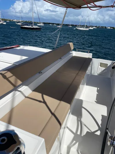 Pasha Yacht Photos Pics Lagoon 450F 2012 yacht deck with beige seating, anchored in a scenic harbor.