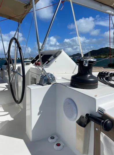 Pasha Yacht Photos Pics Steering wheel and controls on a 2012 Lagoon 450F catamaran under a clear blue sky.