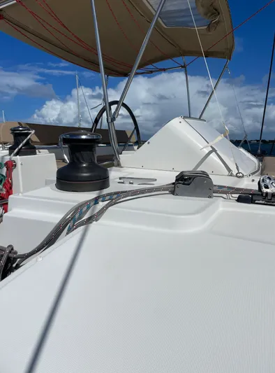 Pasha Yacht Photos Pics 2012 Lagoon 450F yacht deck with winch, ropes, and steering wheel under blue sky.