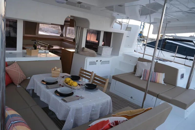 Pasha Yacht Photos Pics Luxurious Lagoon 450F yacht interior with dining setup, featuring elegant seating and tableware.