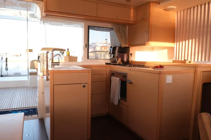 Pasha Yacht Photos Pics Interior of 2012 Lagoon 450F yacht kitchen with modern amenities and wooden cabinetry.