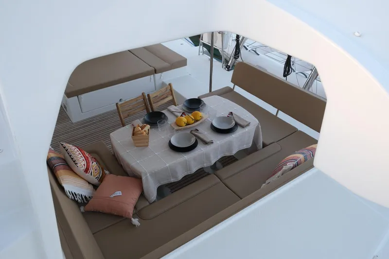 Pasha Yacht Photos Pics Outdoor dining setup on 2012 Lagoon 450F yacht with cushions and tableware.